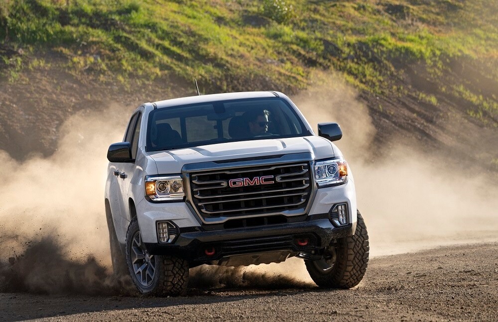 GMC truck driving in the sand and gravel.